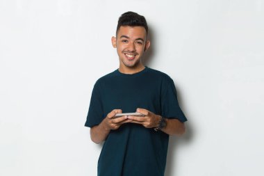 mutlu genç adam cep telefonuyla beyaz zemin üzerine izole