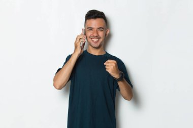 mutlu genç adam cep telefonuyla beyaz zemin üzerine izole