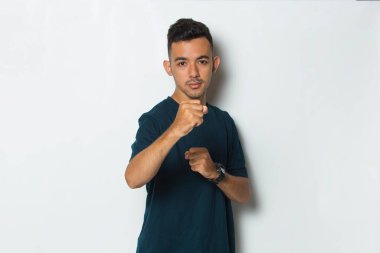 Genç adamın portresi kameraya bakıyor dövüşmeye hazır, yumruğu yakın.