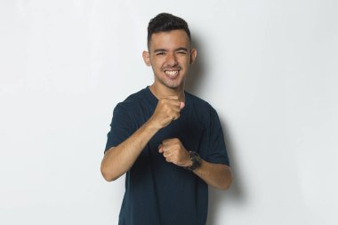 Genç adamın portresi kameraya bakıyor dövüşmeye hazır, yumruğu yakın.