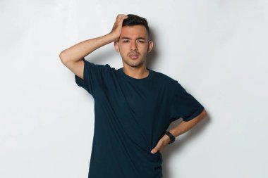 Beyaz arka planda baş ağrısı olan stresli genç bir adamın portresi.