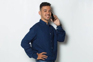 Mutlu genç iş adamı beyaz arka planda izole cep telefonu kullanıyor.