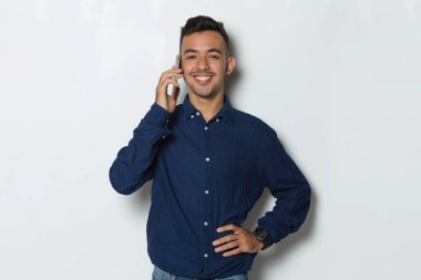 Mutlu genç iş adamı beyaz arka planda izole cep telefonu kullanıyor.