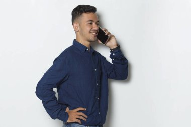 Mutlu genç iş adamı beyaz arka planda izole cep telefonu kullanıyor.