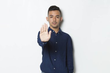 Eli açık yakışıklı genç bir iş adamı ciddi ifade ile dur işareti yapıyor savunma hareketi beyaz arka planda izole