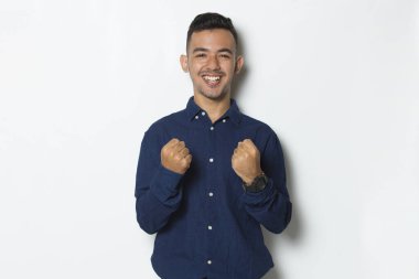 Yakışıklı iş adamı mutlu ve heyecanlı zaferi kutluyor ve beyaz arka planda büyük başarı gösteriyor.