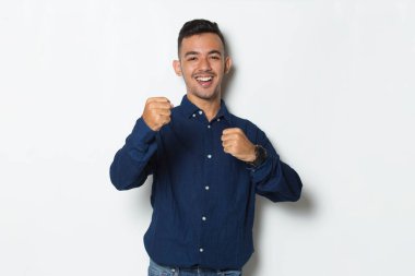 Yakışıklı iş adamı mutlu ve heyecanlı zaferi kutluyor ve beyaz arka planda büyük başarı gösteriyor.