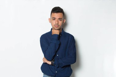 Genç yakışıklı iş adamı beyaz arka planda soyutlanmış düşünüyor.