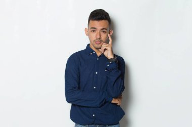 Genç yakışıklı iş adamı beyaz arka planda soyutlanmış düşünüyor.