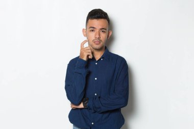 Genç yakışıklı iş adamı beyaz arka planda soyutlanmış düşünüyor.