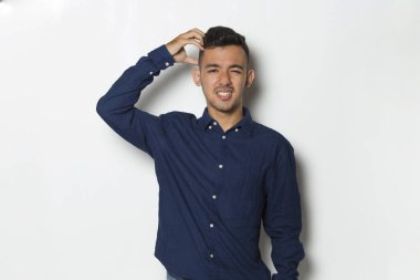 Beyaz arka planda elleri izole bir şekilde kafasını kaşıyan yakışıklı bir iş adamı.