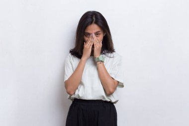 Beyaz arka planda baş ağrısı olan stresli Asyalı güzel bir kadının portresi