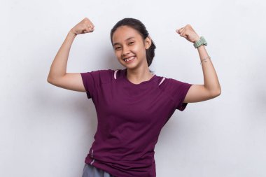 Genç sporcu Asyalı güzel beyaz arka planda güçlü bir jest sergiliyor