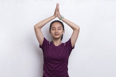 Genç, güzel Asyalı spor kadın yoga yapıyor, beyaz arka plan üzerinde meditasyon yapıyor.