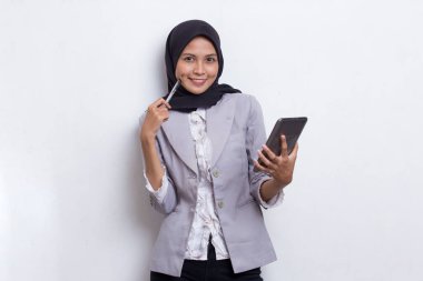 Mutlu genç Asyalı güzel Müslüman kadın beyaz arka planda izole edilmiş cep telefonu kullanıyor.