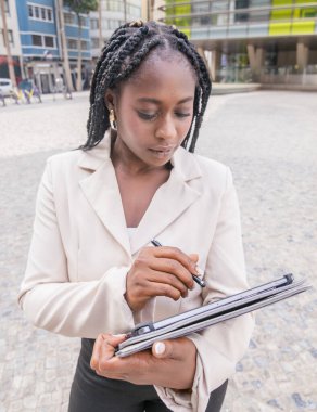 Tablet üzerinde çalışan Afro kökenli bir iş kadınının yakın plan fotoğrafı.