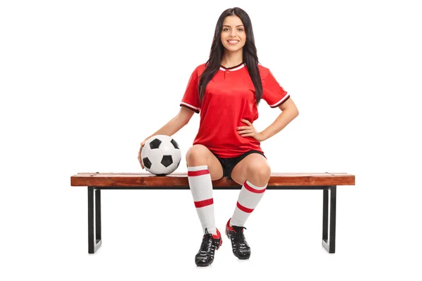 Female soccer player sitting on a bench — Stock Photo, Image