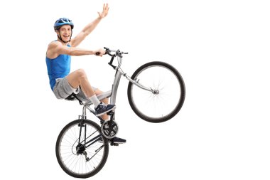 Kendine güvenen genç Motorcu bir wheelie gerçekleştirme 
