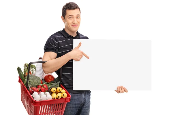 Man carrying a shopping basket and a panel — Stock Photo, Image