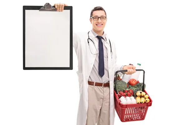 Médico segurando cesta de compras e área de transferência — Fotografia de Stock