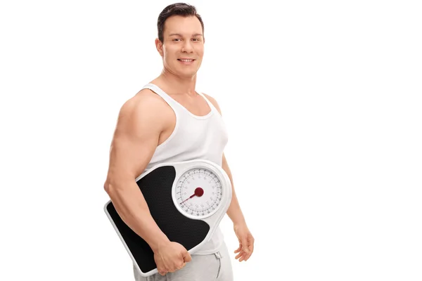 Homem muscular segurando uma balança de peso — Fotografia de Stock