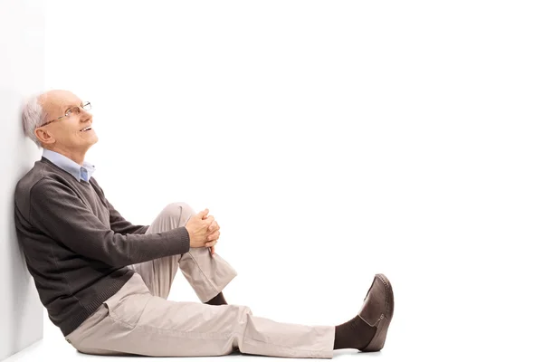 Fröhlicher älterer Herr auf dem Fußboden sitzend — Stockfoto