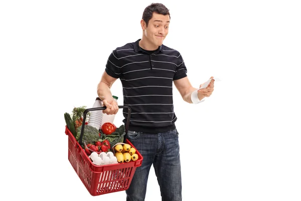 Displeased guy looking at the shopping bill — Stock Photo, Image