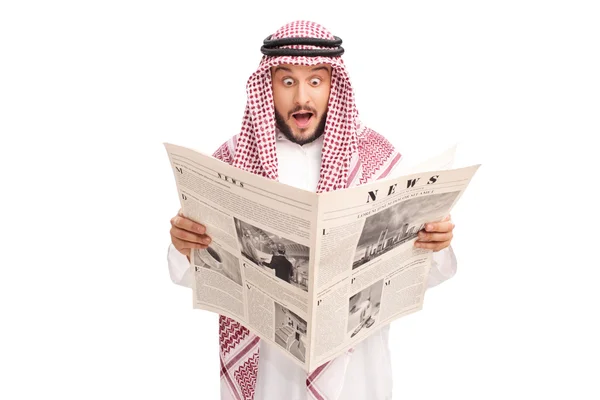 Sorprendido joven árabe leyendo un periódico — Foto de Stock