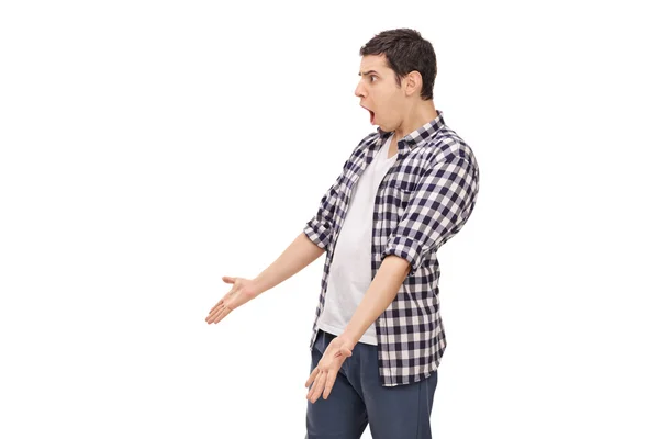 Angry young man arguing with someone — Stock Photo, Image