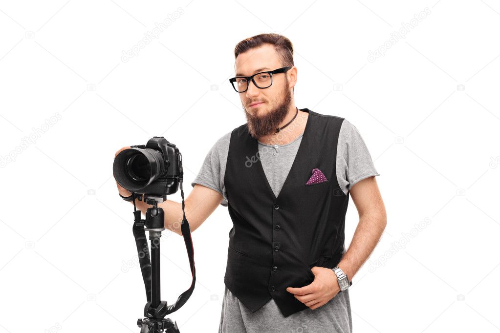 Young male hipster holding a camera 