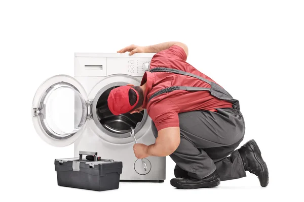 Repairman examining a washing machine — Stock Photo, Image