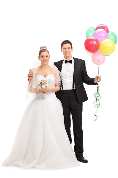 Newlywed couple holding balloons — Stock Photo, Image