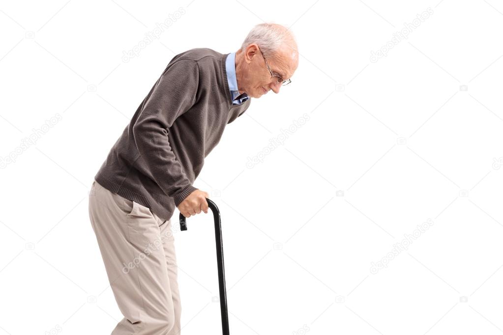 Exhausted old man walking with a cane 