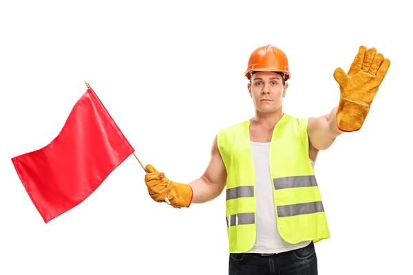 Trabajador de la construcción ondeando una bandera roja — Foto de Stock