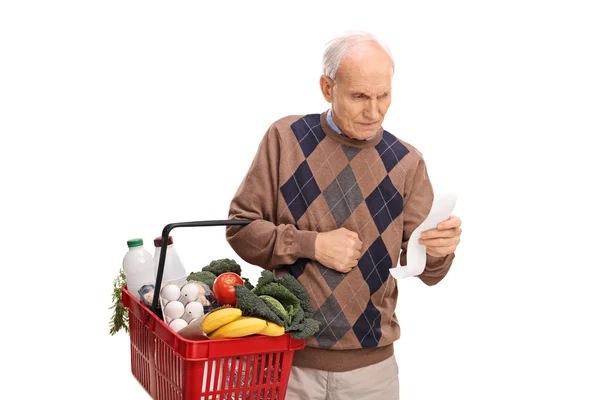 Starszy człowiek czytając listę zakupów — Zdjęcie stockowe