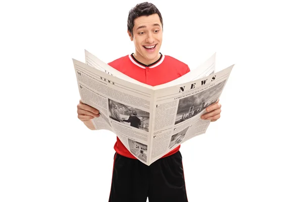 Homem alegre em uma camisola lendo um jornal — Fotografia de Stock