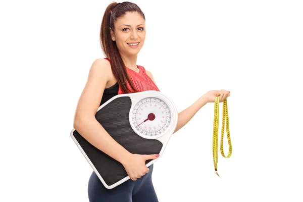 Girl holding weight scale and measuring tape — Stock Photo, Image