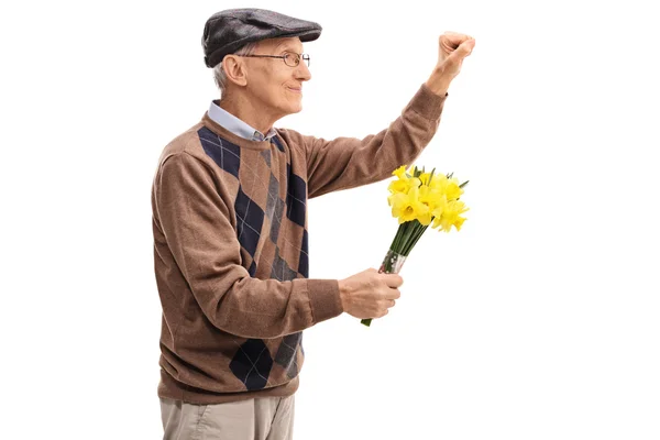 Hombre mayor sosteniendo flores y llamando a una puerta — Foto de Stock