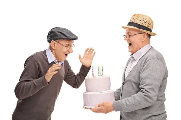 Uomo anziano portando torta al suo amico — Foto Stock