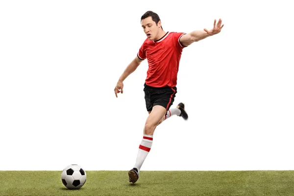 Joven jugador de fútbol pateando una pelota — Foto de Stock