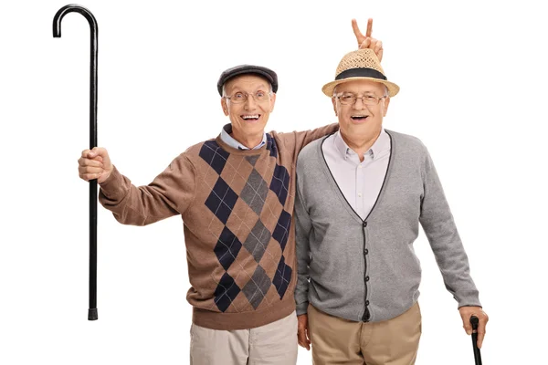 Senior man pulling a bunny fingers prank on his friend — Stock Photo, Image