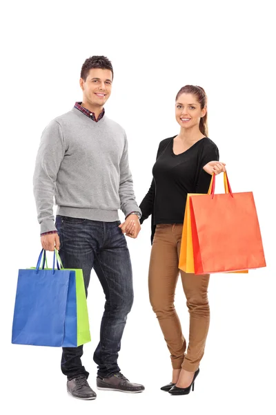 Jovem casal segurando sacos de compras — Fotografia de Stock