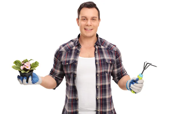 Tuinman holding een bloempot en een hark — Stockfoto