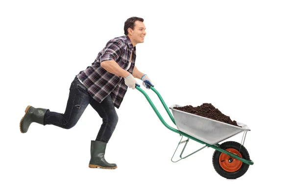 Trädgårdsmästare trycka en skottkärra full av smuts — Stockfoto
