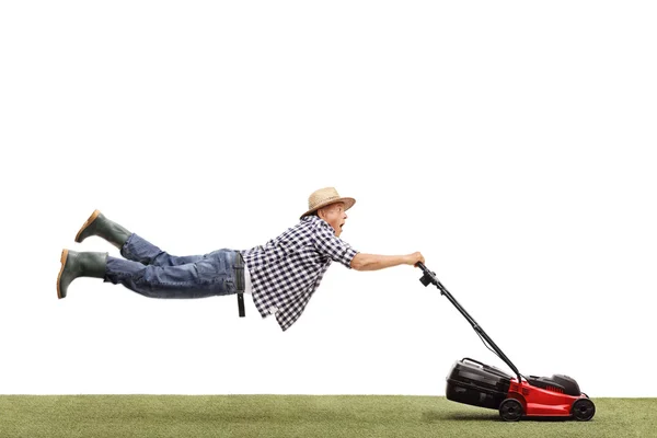 Älterer Mann wird vom Rasenmäher gezogen — Stockfoto