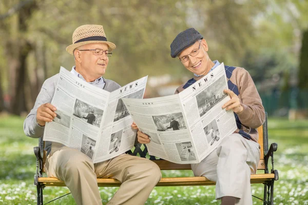 Starší pán, čtení novin v parku — Stock fotografie