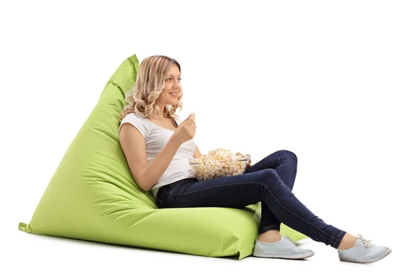 Gadis makan popcorn duduk di beanbag — Stok Foto