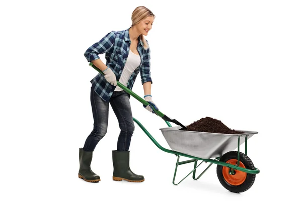 Mujer sacando tierra de una carretilla — Foto de Stock