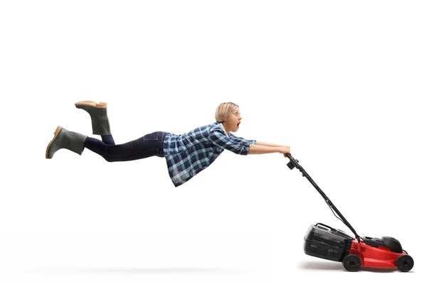 Female gardener being pulled by a lawnmower — Stock Photo, Image