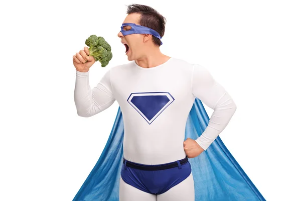 Giovane supereroe mangiare broccoli — Foto Stock
